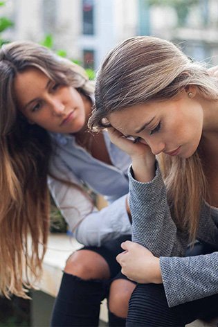 Woman comforting another woman