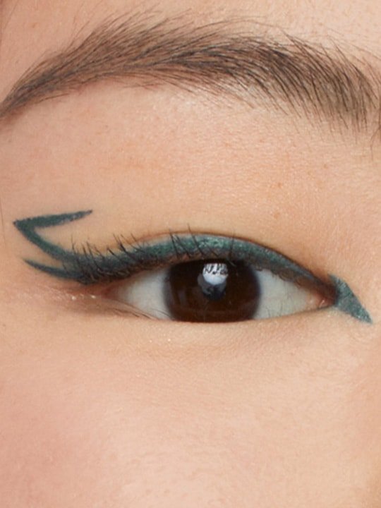 close-up of model wearing a green double-winged eyeliner look