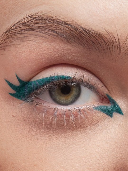 close-up of model wearing a different eyeliner style in green