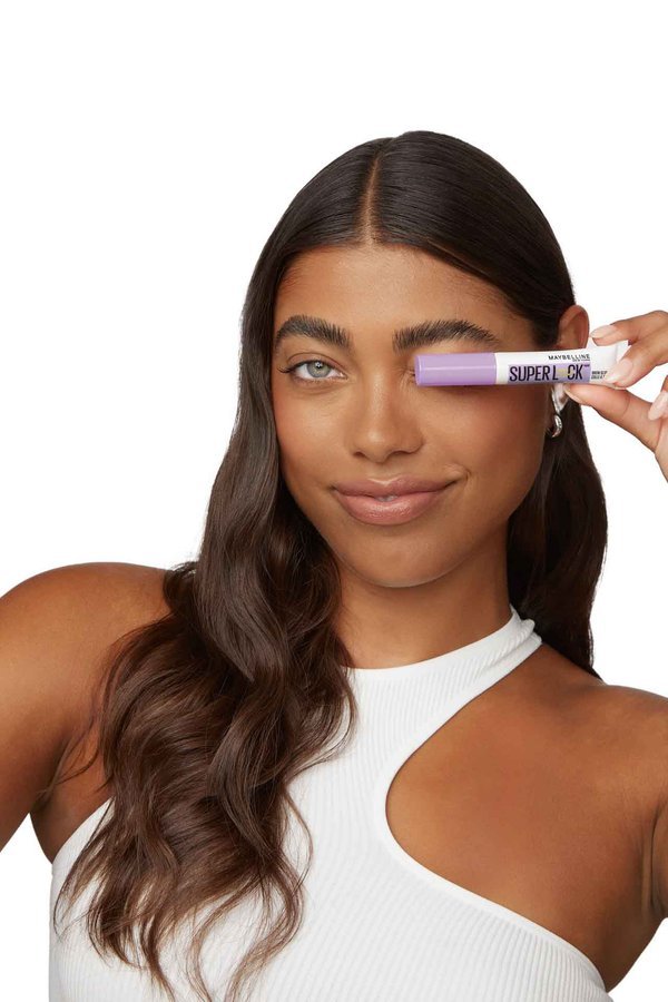 close-up of woman’s face holding the Superlock Brow Glue for a clean girl makeup look