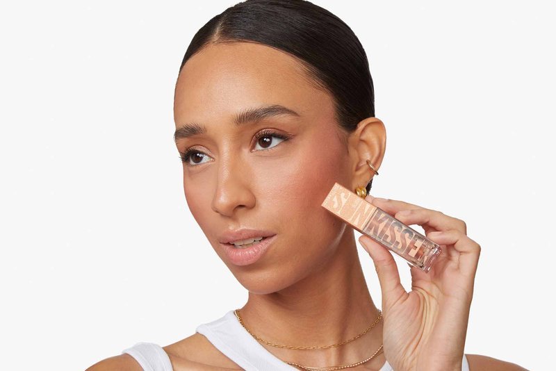 close-up of woman’s face as she holds the Maybelline Sunkisser blush for a clean girl look