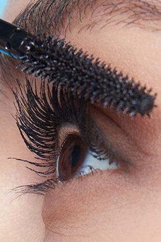 Close up of a woman applying mascara on her Eyelashes