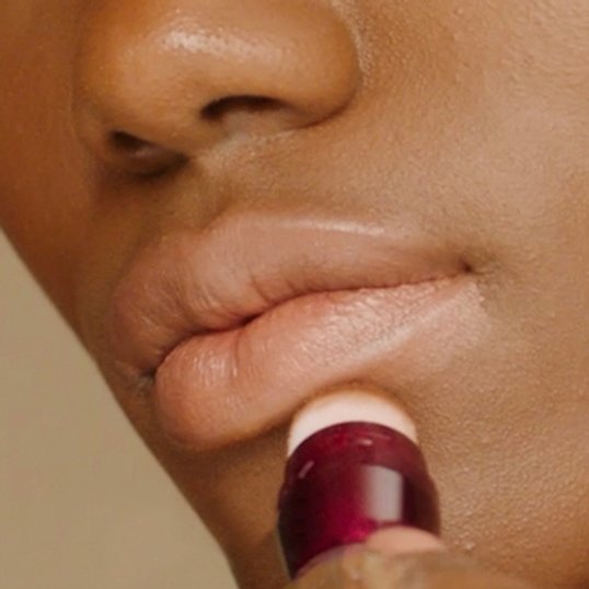 Woman applying Instant Age Rewind underneath lips